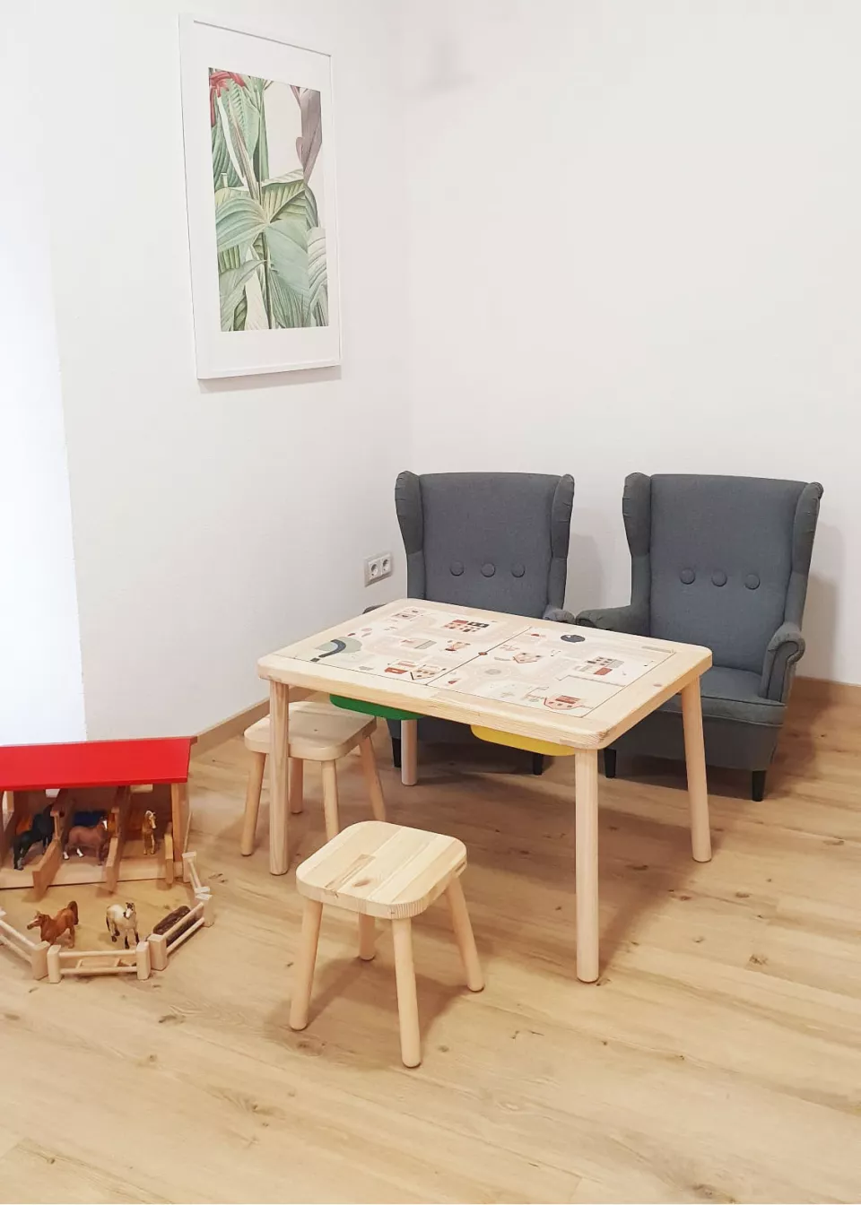 Einladender Spielbereich in der Praxis Seeger & Tändler mit kindgerechtem Tisch, Stühlen, Spielzeug und gemütlichen Sesseln für eine entspannte Atmosphäre.