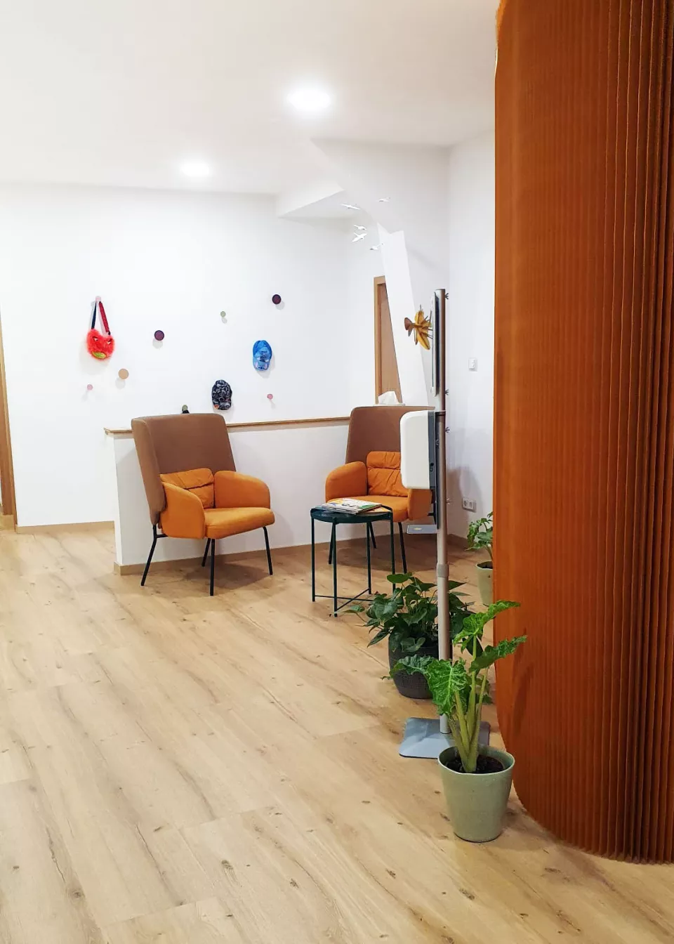 Einladender Wartebereich der Praxis Seeger & Tändler mit gemütlichen Sesseln, Spielaccessoires und Pflanzen für eine angenehme Atmosphäre für Kinder und Eltern.